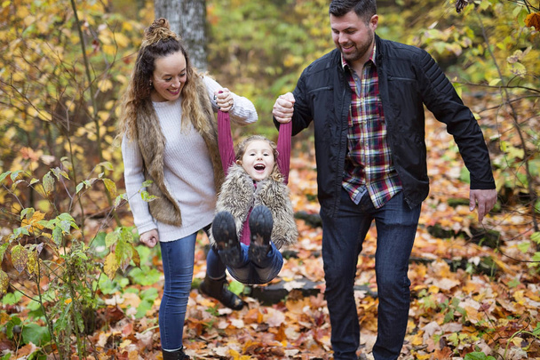 Happy family outdoor in park at autumn. - Фото, изображение