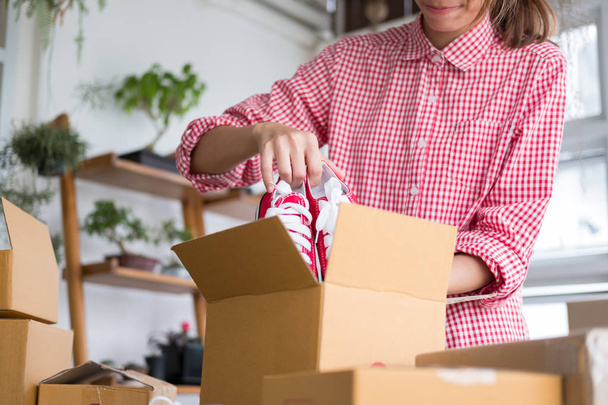 запустити власнику малого бізнесу упаковку взуття в коробці на робочому місці
 - Фото, зображення