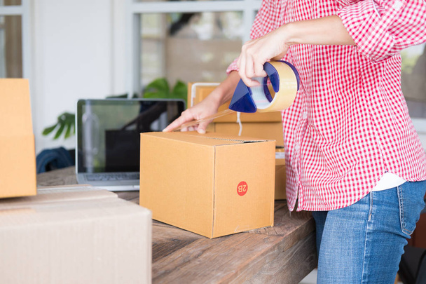 start up small business owner packing cardboard box at workplace - Photo, Image
