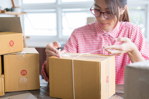 Start-up kleine ondernemer verpakking kartonnen doos op de werkplek - Foto, afbeelding