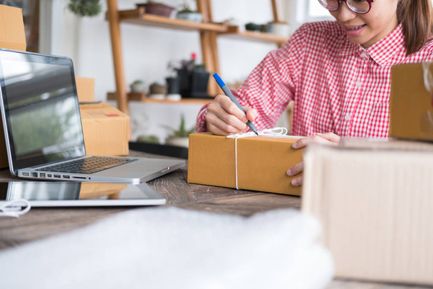 start up small business owner writing address on cardboard box a - Photo, Image