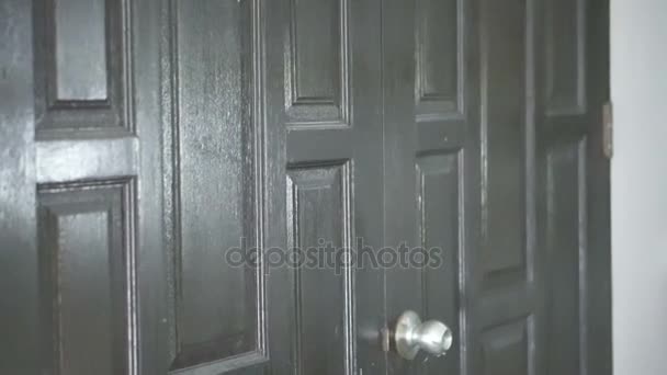 Iemand is houten deur naderen en proberen binnen te komen - Video