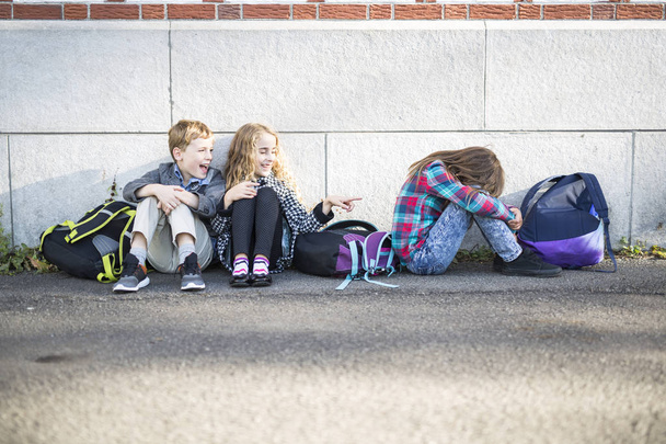 primary students outside at school standing sad - Photo, Image