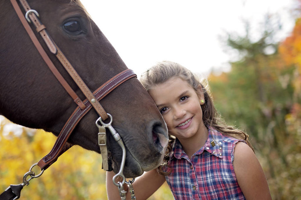 Autumn season young girl and horse - Foto, afbeelding