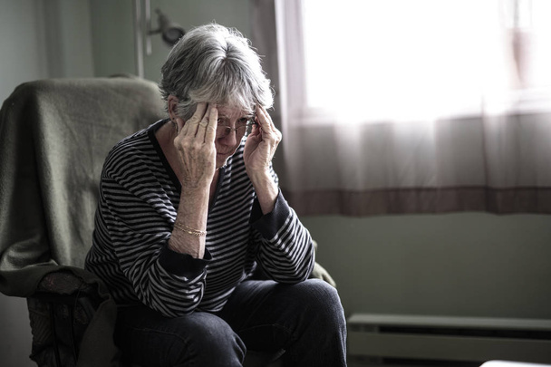 worried senior woman at home felling very bad - Foto, imagen