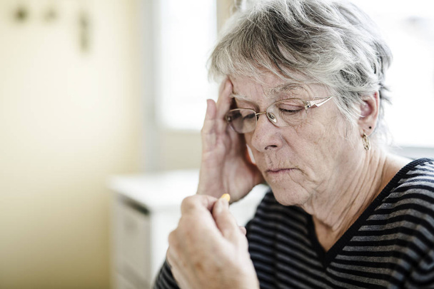 Beteg idősebb nő vesz neki tabletták otthon - Fotó, kép