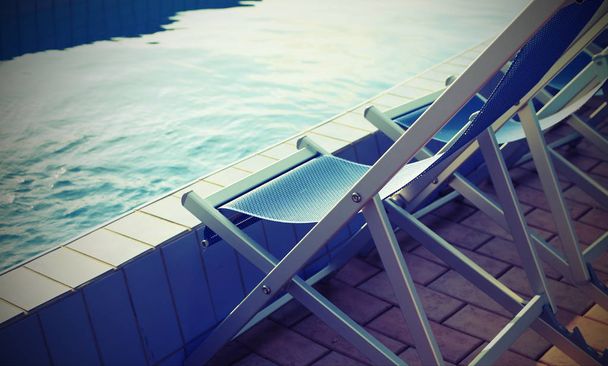 Cadeiras de convés vazias na borda da piscina do spa sem pessoas
 - Foto, Imagem