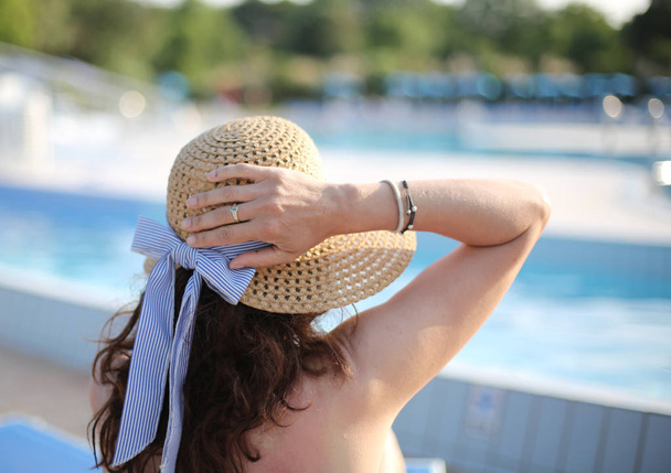femme avec chapeau de paille bronzage dans le complexe de luxe exclusif
 - Photo, image