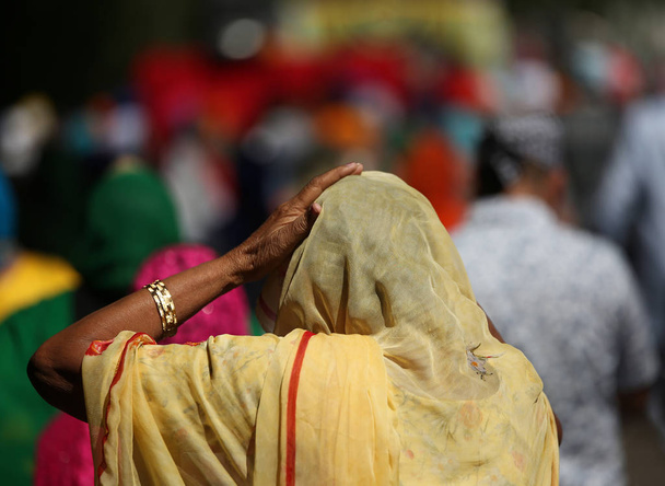 anciana con pañuelo en la cabeza durante una ceremonia religiosa al aire libre
 - Foto, imagen