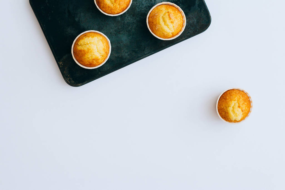 orangefarbene Muffins auf einem Vintage-Blech, auf weißem Hintergrund, Minimalismus - Foto, Bild