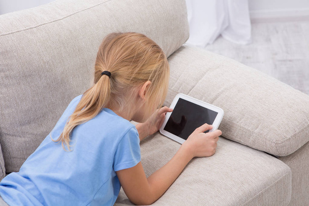 Sick child staying at home palying games on tablet. - Fotó, kép