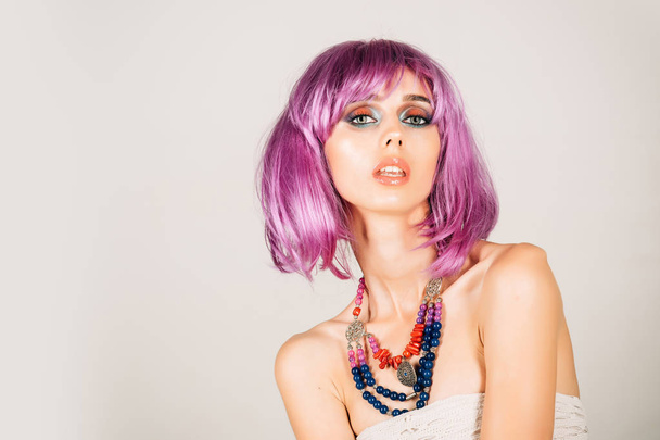 Girl with bright artificial hair in ethnic jewelry. - Фото, изображение