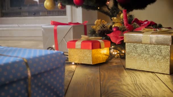 ζουμ κουκλίτσα 4 k σε βολή του πλαίσιο χρυσή δώρο σε ξύλινο πάτωμα κάτω από το χριστουγεννιάτικο δέντρο στο σαλόνι - Πλάνα, βίντεο