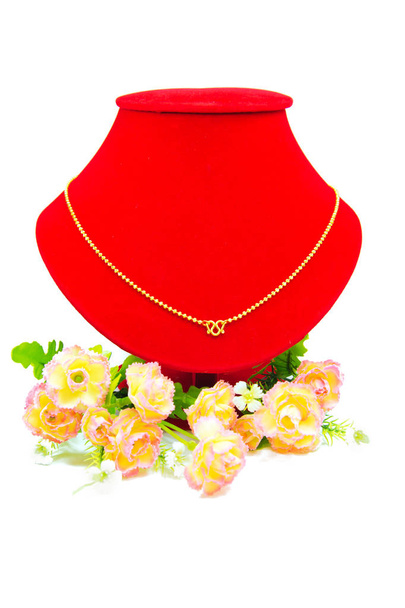 Zlatý náhrdelník na červenou látkou izolované na bílém - Fotografie, Obrázek