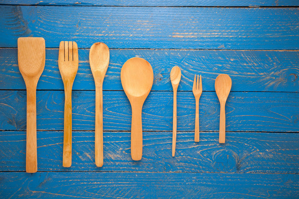 Wooden spoon and fork on blue wood table background. - Foto, Imagem