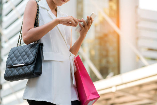 Donna felice con shopping bag utilizzando il telefono cellulare
 - Foto, immagini