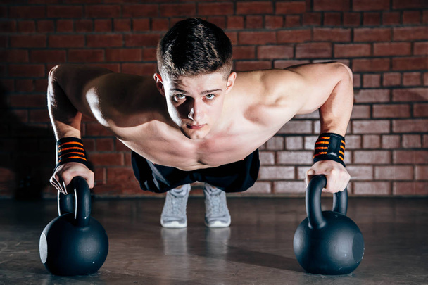 Sport. Young athletic man doing push-ups. Muscular and strong guy exercising. - Fotó, kép