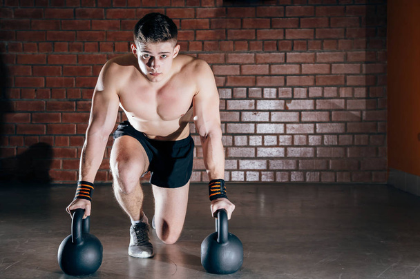Shot of healthy muscular young man doing weight exercise with dumbbells. - Фото, зображення