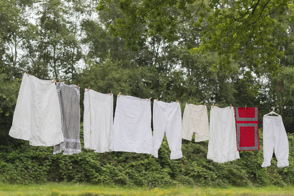 服と昔ながらの洗濯物 - 写真・画像