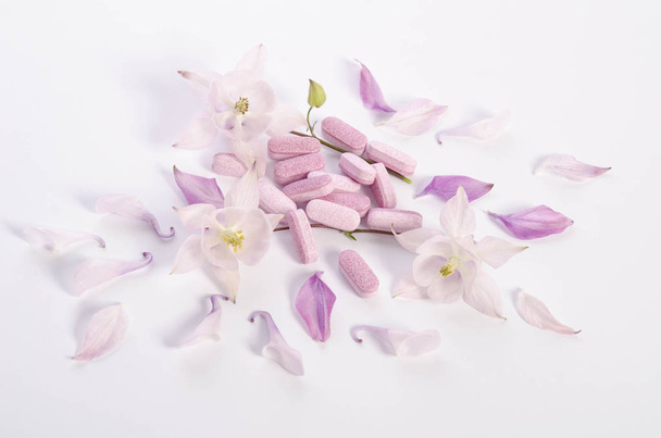Medycyna alternatywna tabletki z kwiatami i płatki na stole - Zdjęcie, obraz