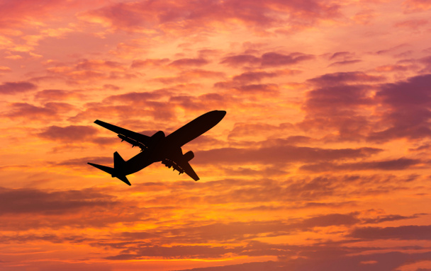   Avion silhouette s'envolant dans le ciel pendant le coucher du soleil
 - Photo, image