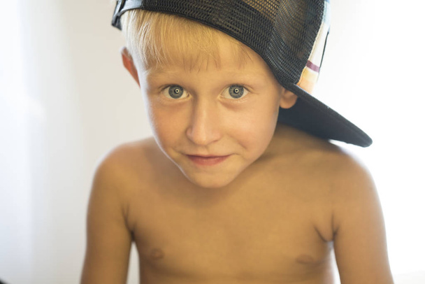 Πορτρέτο του ένα γυμνό μικρό αγόρι σε ένα καπάκι.  - Φωτογραφία, εικόνα