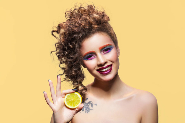 Χαμογελαστή γυναίκα εκμετάλλευση λεμόνι φέτα. - Φωτογραφία, εικόνα