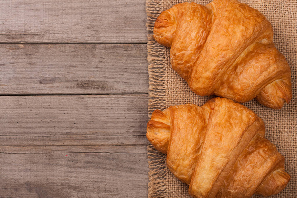 two croissants on old wooden background with copy space for your text. Top view - Photo, Image