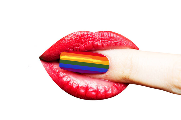 Manicure colori bandiera arcobaleno di LGBT. Chiodo vicino alla bocca femminile. Labbra con rossetto di ragazza giovane, stile di trucco e manicure. Femmina bocca sexy con dito isolato su sfondo bianco
 - Foto, immagini