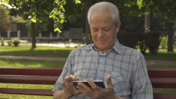 Idősebb ember használ tabletta a padon - Felvétel, videó