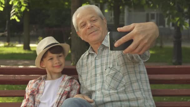 Старший мужчина делает селфи со своим внуком
 - Кадры, видео