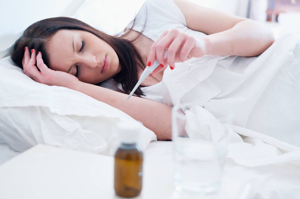 Mujer enferma sintiéndose mal y acostada en la cama
 - Foto, imagen
