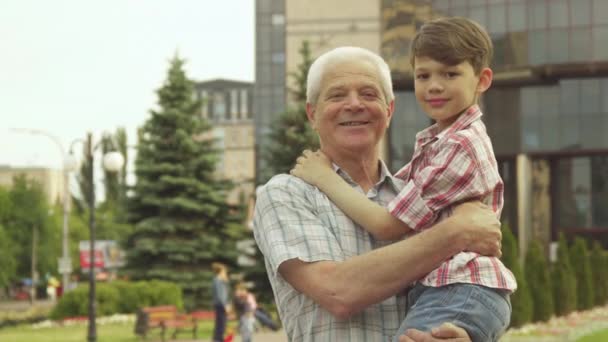 Hombre mayor sostiene a su nieto en sus brazos
 - Imágenes, Vídeo