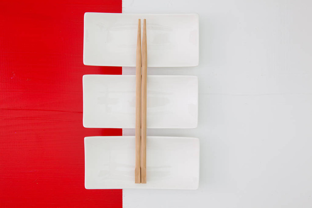 Empty ceramic bowls and bamboo chopsticks for sushi food - Fotó, kép