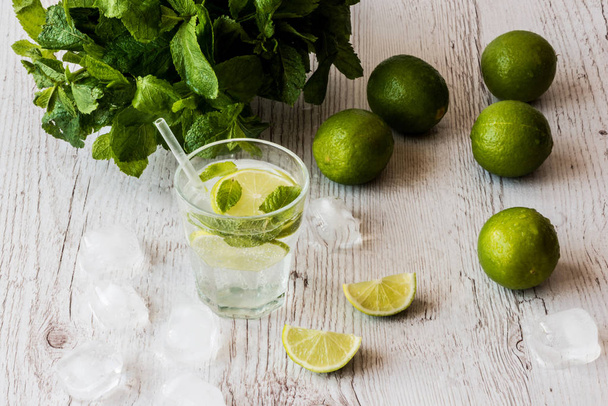 Cocktail mojito au citron vert, menthe et glace sur fond de bois blanc
. - Photo, image