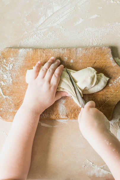 Дитина ріже сире тісто
 - Фото, зображення