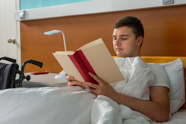 Portrait of ill male patient lying in the hospital bed and readi - Foto, afbeelding
