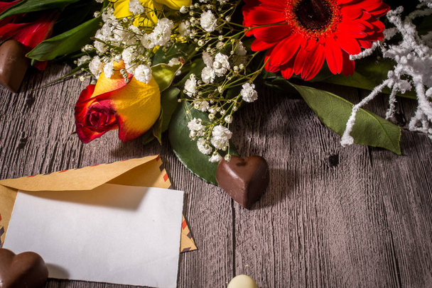 Tarjeta de felicitación del día de San Valentín, flores y chocolates en el coro
 - Foto, imagen
