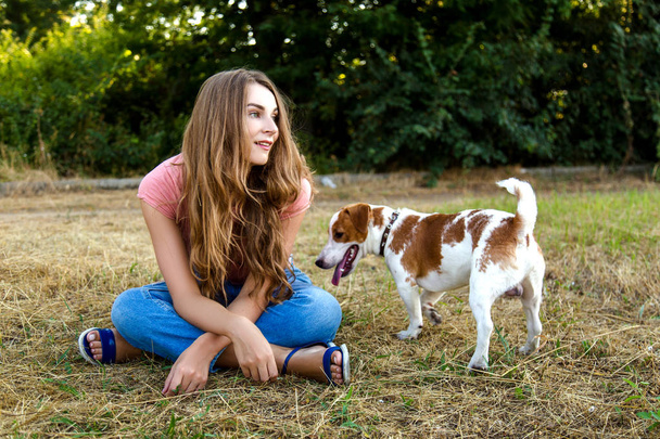 Χαριτωμένο κορίτσι παίζει με το σκύλο στο πάρκο - Φωτογραφία, εικόνα