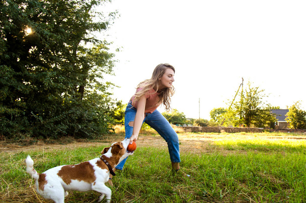 Χαριτωμένο κορίτσι παίζει με το σκύλο στο πάρκο - Φωτογραφία, εικόνα