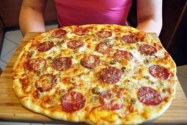 Pizza de linguiça redonda Margherita em uma chapa branca
.  - Foto, Imagem