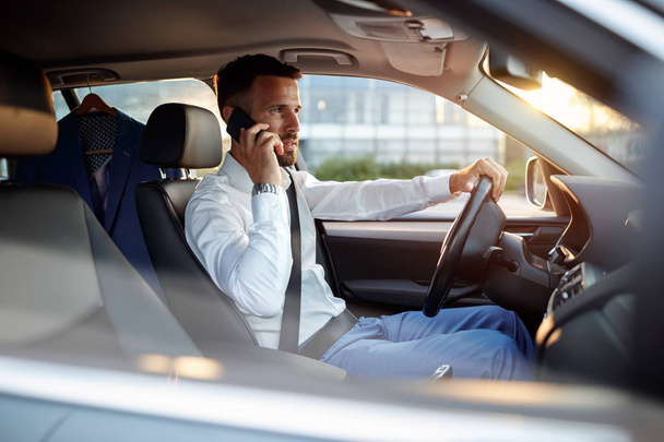 Businessman using phone in the car - Foto, afbeelding
