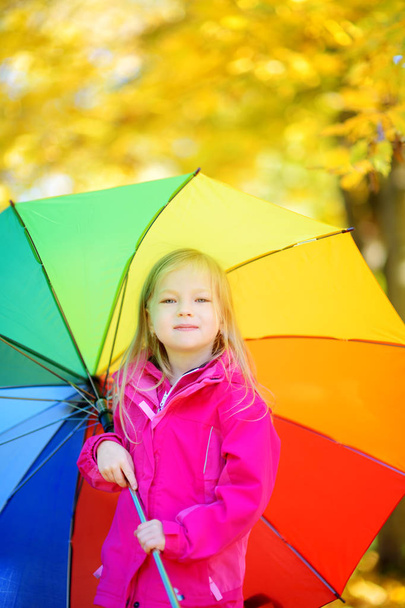 little girl holding rainbow umbrella  - 写真・画像