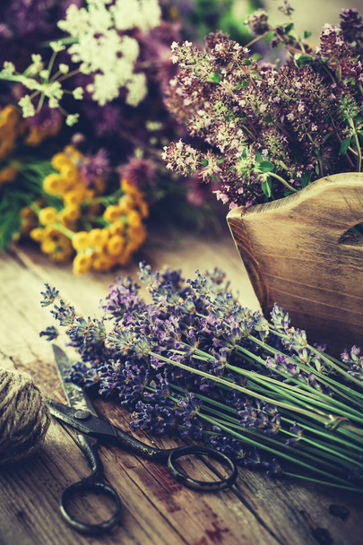 Bunch of lavender, thyme flowers in wooden box and healing herbs on background. Herbal medicine. Retro toned. - Fotoğraf, Görsel