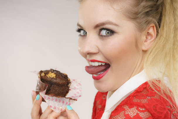 Attractive woman holds cake in hand - Foto, afbeelding