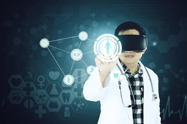 Médico asiático toca um botão na tela futurista
 - Foto, Imagem