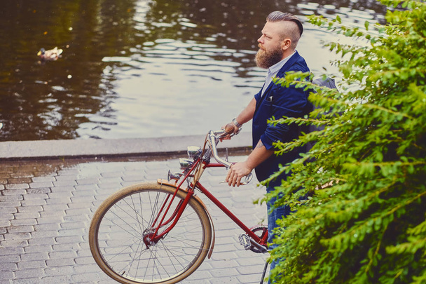 Homme avec vélo rétro dans un parc
 - Photo, image