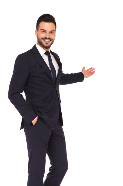 glücklicher junger Geschäftsmann präsentiert und lächelt - Foto, Bild