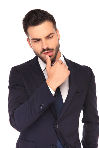 handsome young business man touching lips with his thumb - Фото, изображение