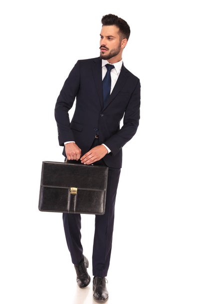jeune homme d'affaires moderne tenant la valise avec les deux mains
  - Photo, image
